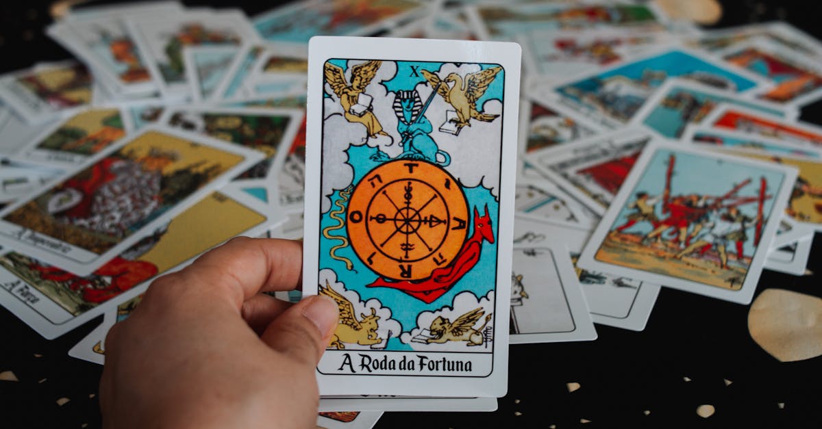 Close-up of a hand holding a tarot card in a deck for a fortune-telling session.