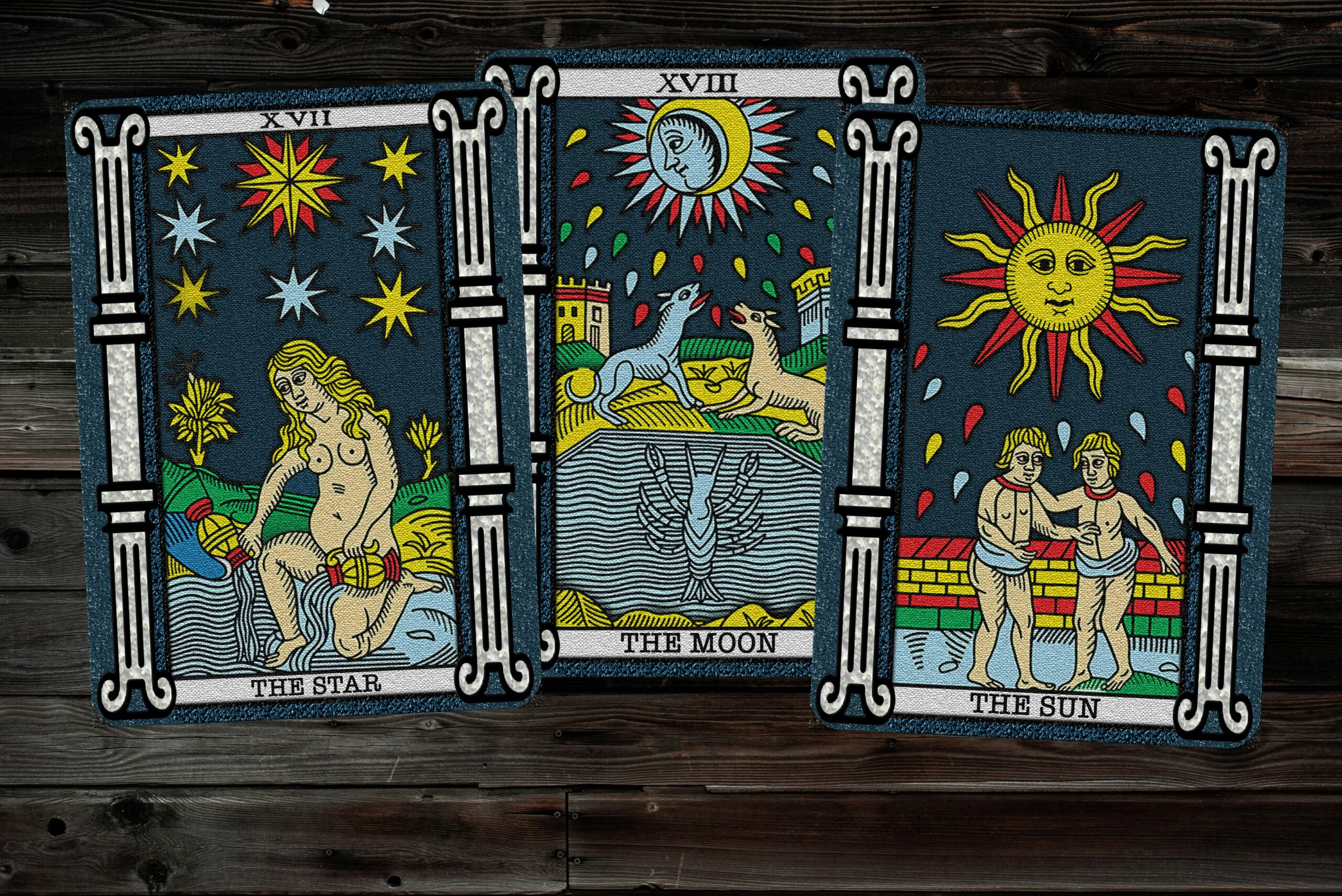 Three tarot cards, The Star, The Moon, and The Sun, laid on a wooden surface.